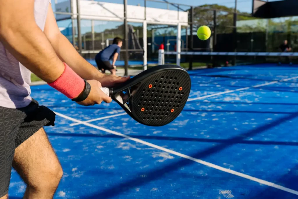Giocatore pronto al servizio durante un match su campo blu: dinamica azione perfetta per il mondo delle Scommesse Padel e del betting sportivo ADM.